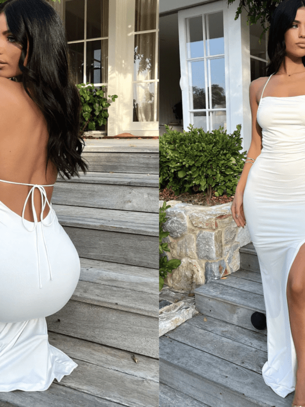 White gown with side split, open back and thin spaghetti straps.