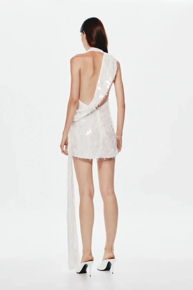 8323-Sapphire Sequin Mini Dress by Misha an ivory asymmetric mini with plunging neckline wrap sash detail and full sequins for radiant allure. 3