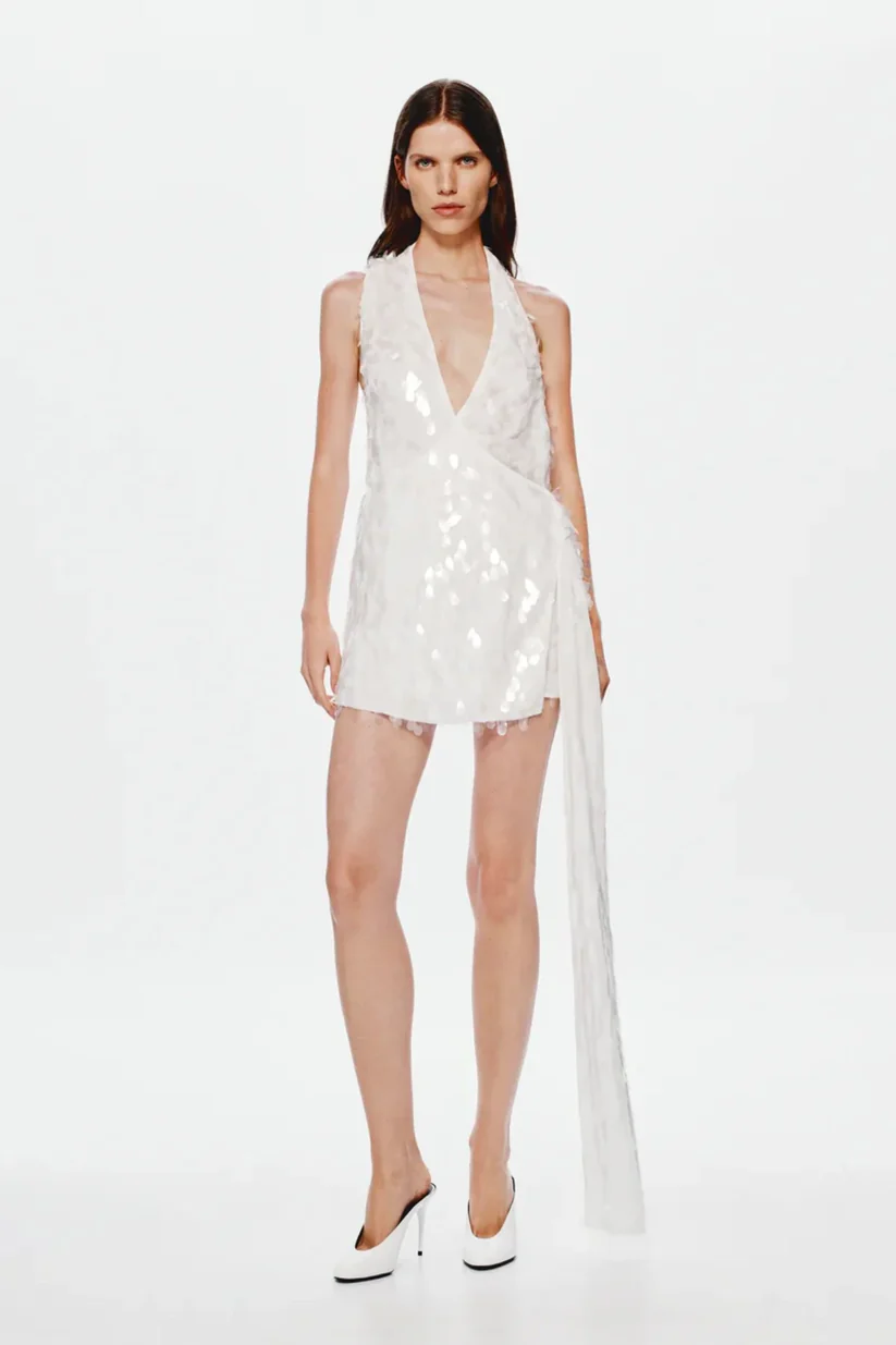 8323-Sapphire Sequin Mini Dress by Misha an ivory asymmetric mini with plunging neckline wrap sash detail and full sequins for radiant allure.