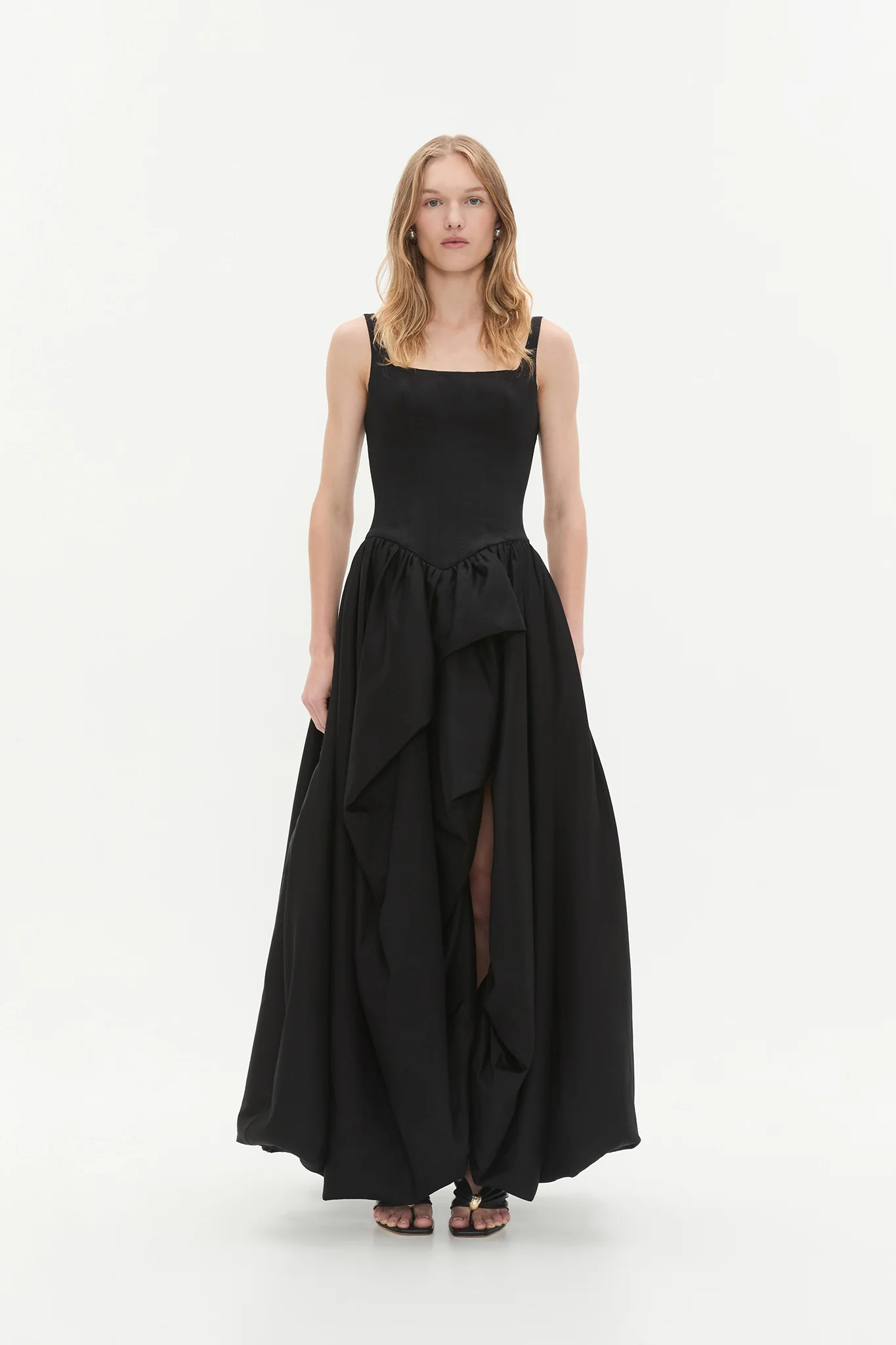 An ankle length a-line black gown with flounces and a slit